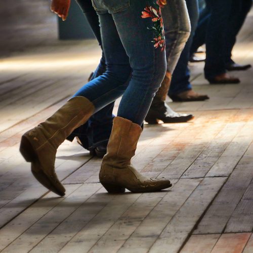 A closeup shot of the legs of traditional western folk dancing under the music